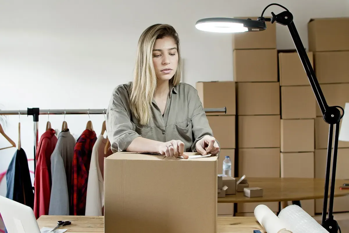 Empreendedora embalando caixas no estoque do seu pequeno negócio