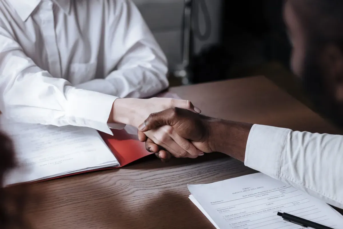 Aperto de mãos entre contador e parceiro sobre o contrato de prestação de serviços contábeis