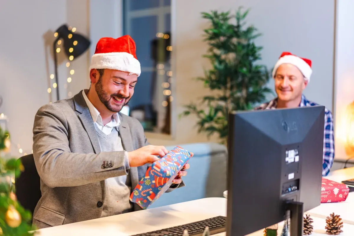 Dois colegas trocando presentes em um escritório decorado para o Natal