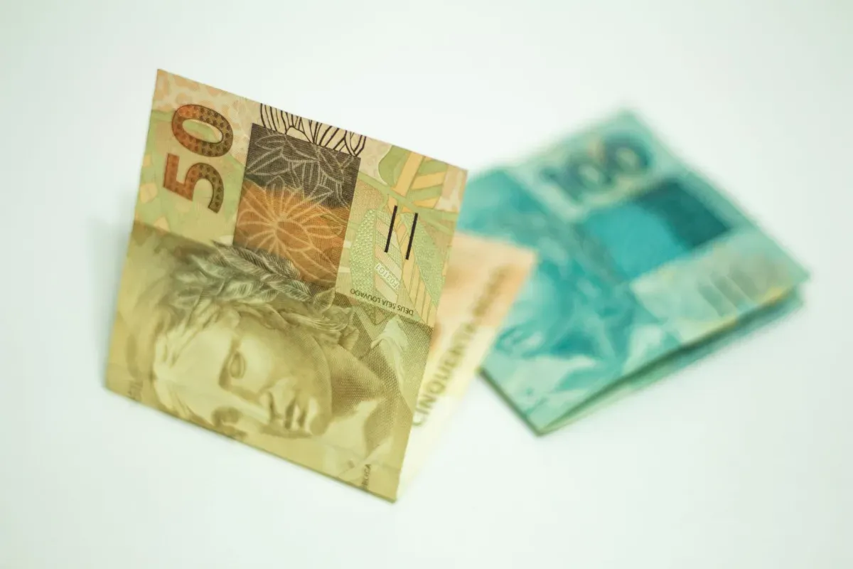 Notas de 50 e 100 reais sobre fundo claro