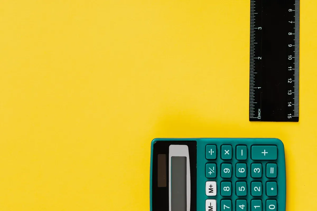 Calculadora e régua sobre fundo amarelo