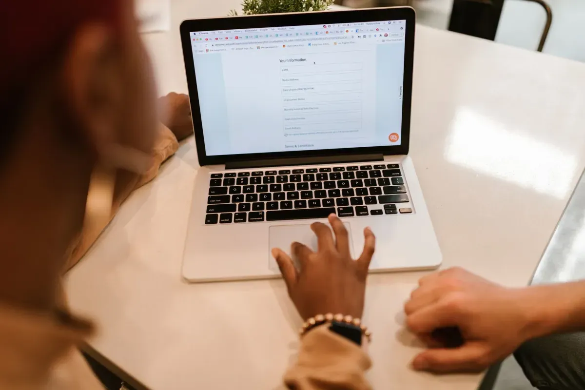 Duas pessoas preenchendo um formulário online no notebook